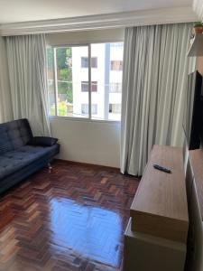 uma sala de estar com um sofá e uma mesa de centro em FAROL DA BARRA 2/QUARTOS em Salvador