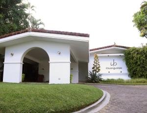 a white building with an arch in front of a yard at Il Buongustaio in San Salvador