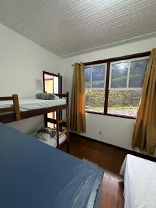 a room with two bunk beds and a window at Pertin da Praça Hostel in Ouro Preto