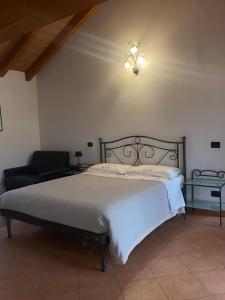 1 dormitorio con 1 cama grande y 1 silla en B&B Molinetto, en Piacenza