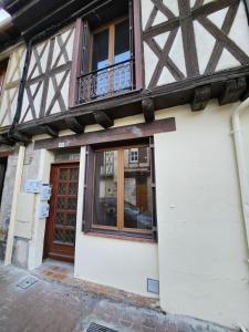 een gebouw met een houten deur en een balkon bij Le meublé de Jules et Jade in Casteljaloux