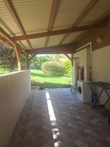 une terrasse avec un toit, une table et des toilettes. dans l'établissement Villa Kikine, au Diamant