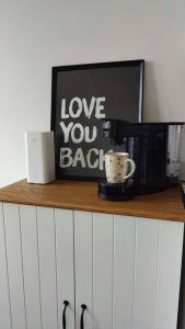 a shelf with a microwave and a coffee cup on it at Lille nest in Rødovre