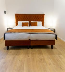 - une chambre avec un grand lit et une tête de lit en bois dans l'établissement Michelangelo Vatican Guest House, à Rome