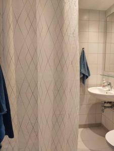 a bathroom with a shower curtain and a sink at Lille nest in Rødovre