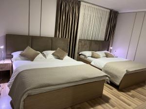 - une chambre d'hôtel avec 2 lits dans l'établissement Freddy's Hotel, à Tirana