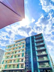 a tall building with the sun in the sky at Marcony Summerland Apartments in Mamaia