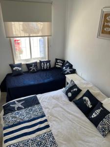 a bedroom with a bed with pillows on it at Muelle Apart Hotel in Tongoy