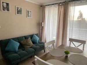 Departamento en Viña del Mar في فينيا ديل مار: غرفة معيشة مع أريكة خضراء وطاولة