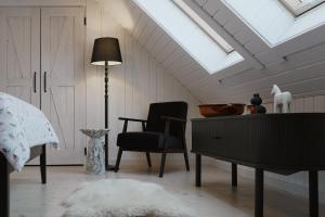 a bedroom with a skylight and a desk and a chair at Pieprz & Sól FARMHOUSES in Załuczne