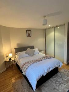 a bedroom with a large bed and a table with a lamp at Chic 1 Bed Centrally Located Apartment - Birmingham JQ in Birmingham