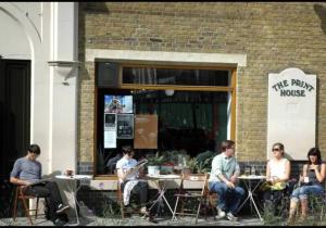 un grupo de personas sentadas en mesas fuera de un edificio en Beautiful Studio Flat in Hackney next to Overground Station en Londres