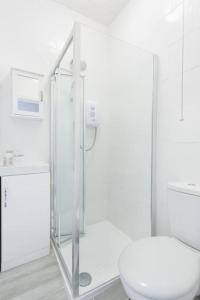 y baño blanco con ducha y aseo. en Beautiful Studio Flat in Hackney next to Overground Station en Londres