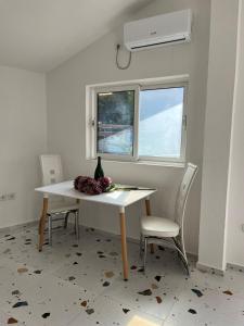 a dining room table with two chairs and a window at La Terrazza in Dobra Voda