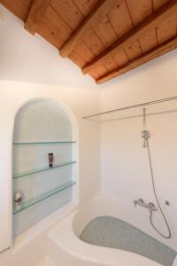 a bathroom with a bath tub and a shower at Aegean Stones in Agios Ioannis Mykonos