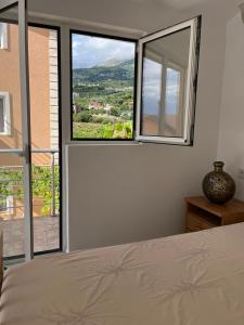 a bedroom with a bed and a large window at La Terrazza in Dobra Voda