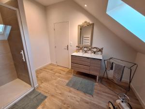 a bathroom with a sink and a mirror at La chambre Mademoiselle Causeuse in Malville