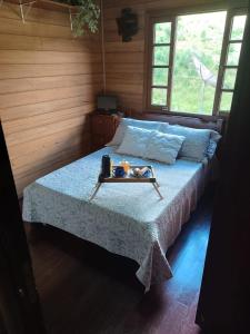 een bed in een kamer met een dienblad met eten erop bij Recanto Flora in Rancho Queimado