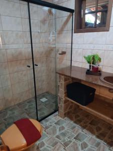 een badkamer met een douche, een toilet en een wastafel bij Recanto Flora in Rancho Queimado