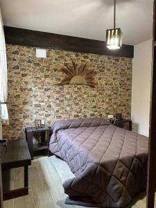 1 dormitorio con cama y pared de ladrillo en Casa Rural La Antigua Fonda (@casarural_laantiguafonda), en Requena