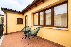 een patio met 2 stoelen en een tafel op een balkon bij Coppito Apartment in Coppito