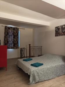 een slaapkamer met een bed met twee blauwe kussens erop bij Chez Sonia in Sarrians