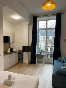 a room with a bed and a kitchen with a window at Studio Opera in Paris