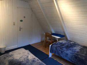 a room with a bed and a table and a door at Lillebo in Lütjensee