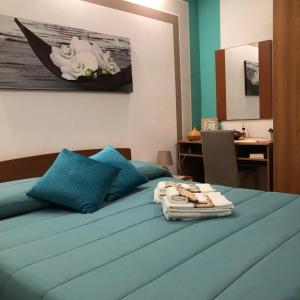 a bed with blue pillows and a desk in a room at Appartamento Rosa in Cefalù