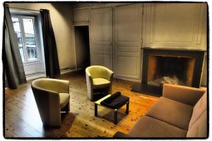 een woonkamer met stoelen, een bank en een open haard bij Appartements de la ferme du Brocey in Crolles