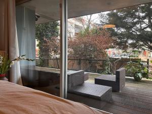 Homestay Properties في أمستردام: غرفة نوم بسرير ونافذة زجاجية كبيرة