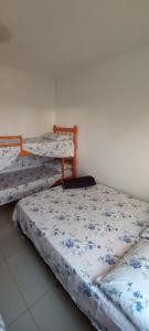Habitación con 3 camas con sábanas azules y blancas. en Vanessa pousada familiar en São Gabriel