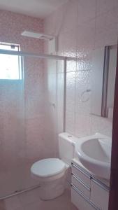 een witte badkamer met een toilet en een wastafel bij Vanessa pousada familiar in São Gabriel