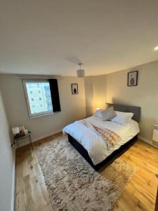 a bedroom with a bed with a window and a rug at Chic 1 Bed Centrally Located Apartment - Birmingham JQ in Birmingham