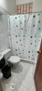 a bathroom with a toilet and a shower curtain at Luna verde hotel in Neiva