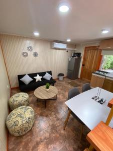 sala de estar con sofá, mesa y sillas en Arriendo de cabaña centro osorno, en Osorno