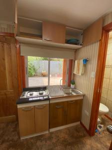 una pequeña cocina con fogones y fregadero en Arriendo de cabaña centro osorno en Osorno