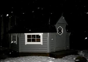 una pequeña casa de perros en la nieve por la noche en Helt hus: Sneveien 75 en Bodø