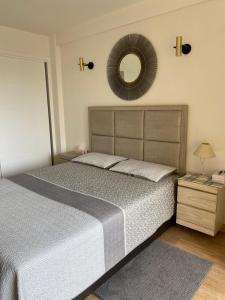 een slaapkamer met een bed en een spiegel aan de muur bij Sea City Torremolinos Golf in Torremolinos