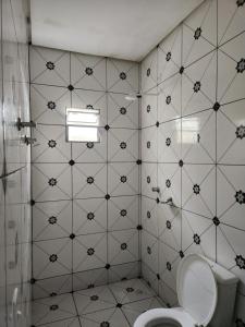 a bathroom with a toilet and a tiled wall at Casa favorita in São Raimundo Nonato