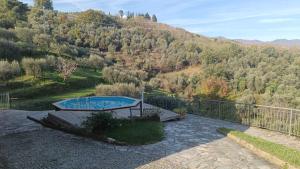 una piscina su un patio con montagna di Casina in pietra a Pistoia
