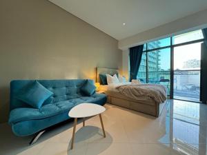 a living room with a couch and a bed at Beachside Bliss: Stylish New Studio at Seven Palm in Dubai