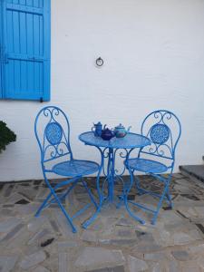 Azienda agricola Affittacamere S'Ispinalba di Laura Pitzolu في Borore: كرسيين وطاولة مع طاولة وكراسي زرقاء