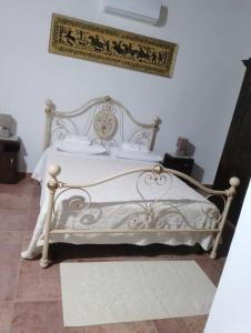 1 cama blanca en un dormitorio con una foto en la pared en Azienda agricola Affittacamere S'Ispinalba di Laura Pitzolu, en Borore