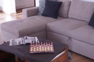 a living room with a couch and a table with chess at Casa Bellavista-Spazioso appartamento in collina a due passi da Bergamo in Sorisole