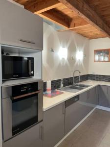 La cuisine est équipée d'un four micro-ondes et d'un évier. dans l'établissement Ti Mamm Gozh, à Plouha