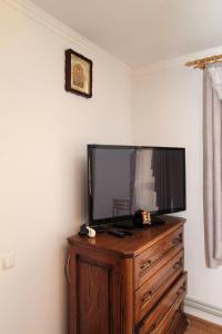 a flat screen tv sitting on top of a wooden dresser at Під Піщиком in Mykulychyn +28 photos