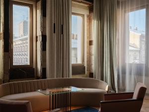a living room with a couch and two windows at Grand Hotel in Łódź