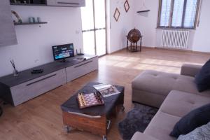 a living room with a couch and a tv at Casa Bellavista-Spazioso appartamento in collina a due passi da Bergamo in Sorisole