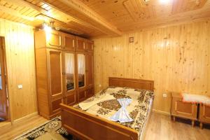 - une chambre avec un lit dans une pièce en bois dans l'établissement Під Піщиком, à Mykulychyn